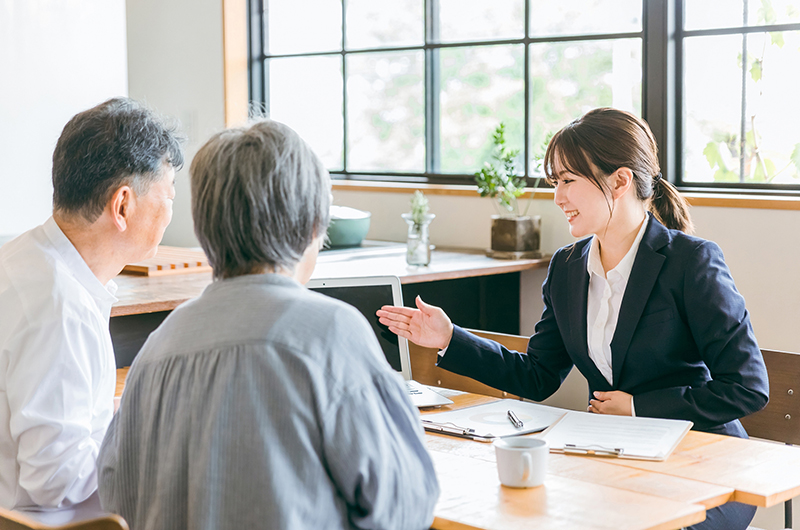 座間市で粗大ゴミを処分したいと考えている夫妻に丁寧に説明する女性営業