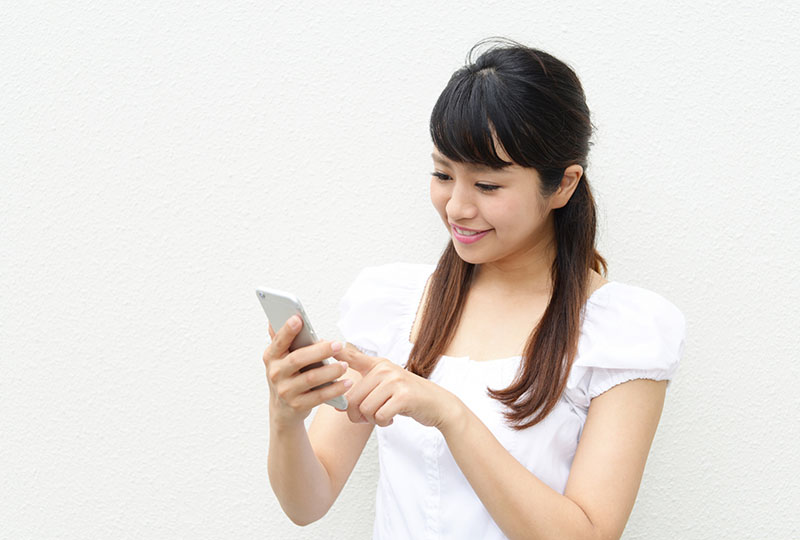 テレビ台の処分するために安心して不用品回収業者に連絡する女性
