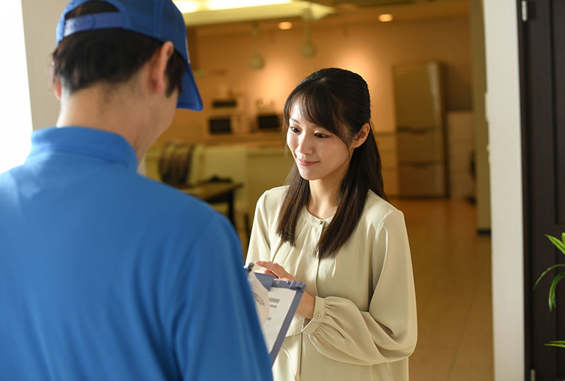 戸田市で粗大ゴミを処分するときは不用品回収業者がおすすめ。業者に相談する女性。