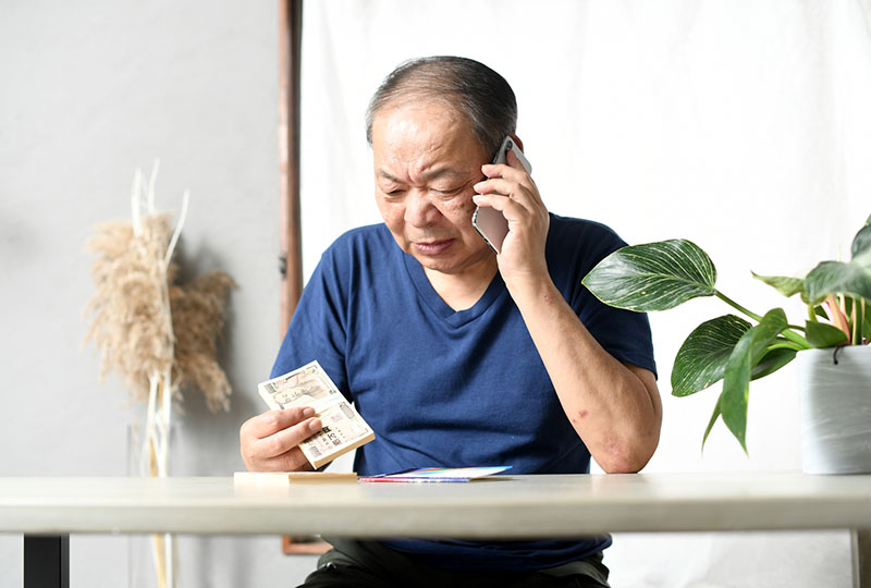 悪徳業者に騙されてしまって消費者センターに電話している男性