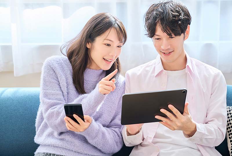 蕨市に住んでいる若い夫婦が、自治体と回収業者のどちらに依頼するか検討している様子