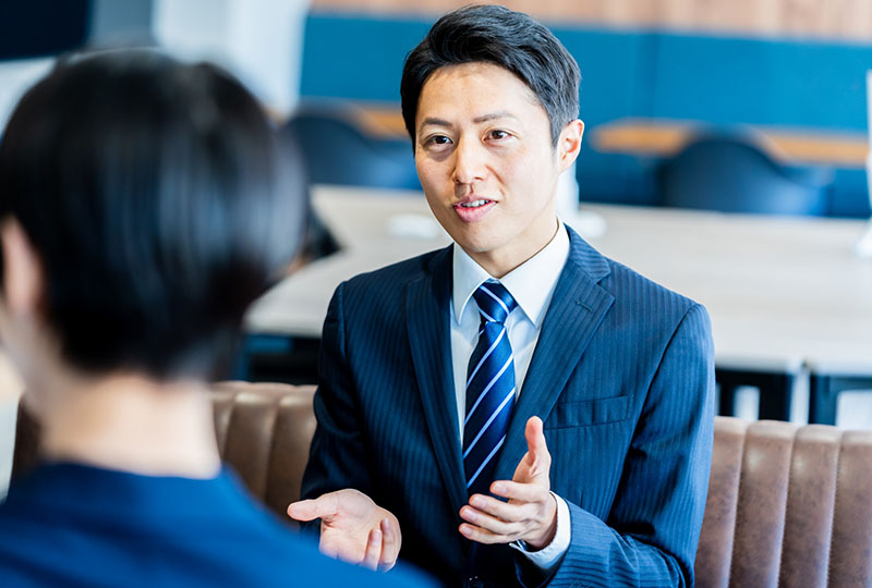 粗大ゴミを手早く処分するために、男性回収業者に相談している女性
